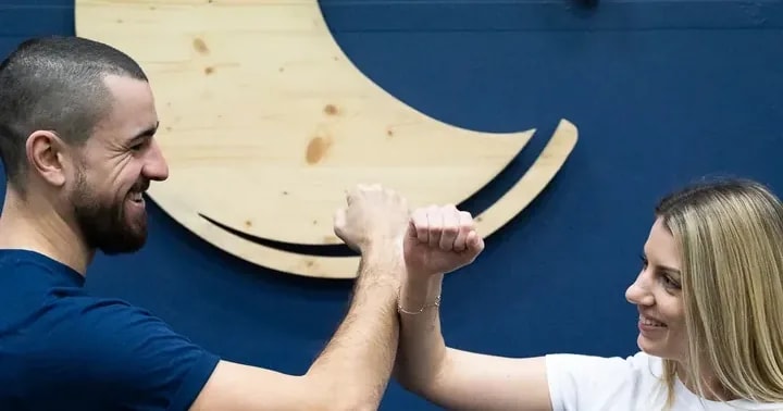 Deux membres de l'équipe des Océades devant le logo de l'enseigne